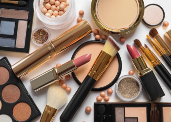 Different luxury makeup products on white background, top view